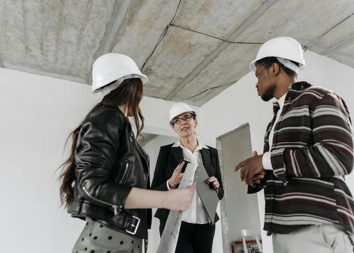Construction risk assessment meeting with safety equipment and blueprints